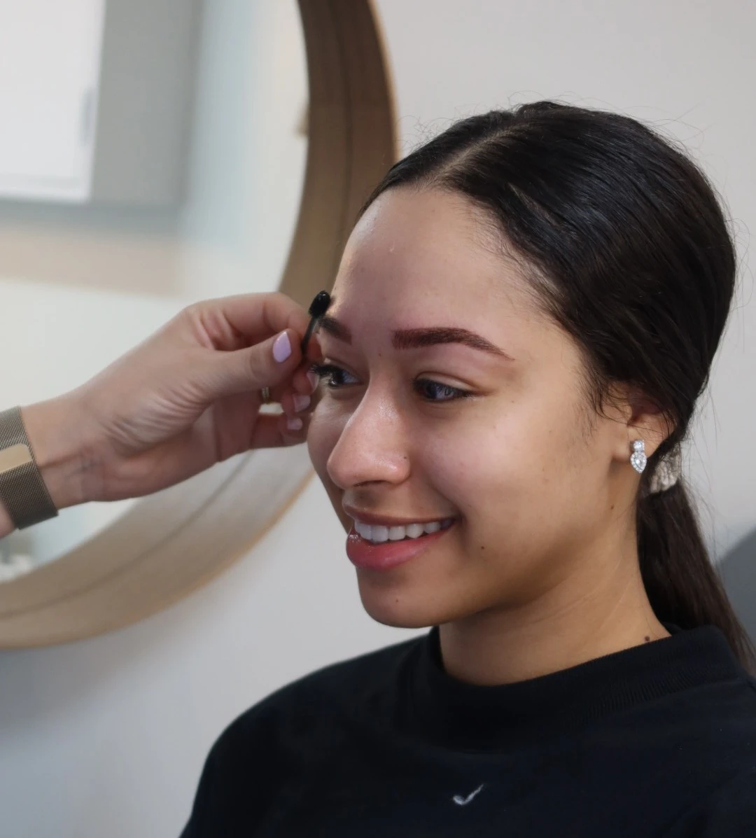 Zahra performing a cosmetic eyebrow tattoo treatment with precision tools.